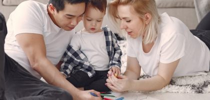 Loving family creating art together, fostering play and connection indoors.