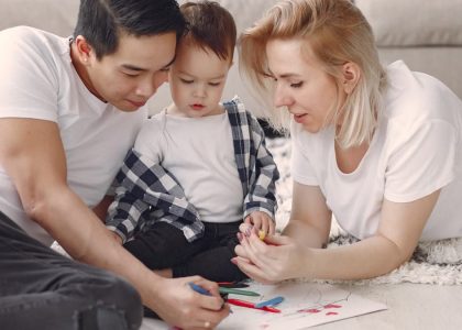 Loving family creating art together, fostering play and connection indoors.